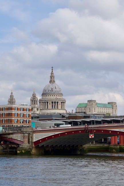 View of the London skyline from across the river, featuring the dome of St. Paul's Cathedral centrally positioned, surrounded by modern skyscrapers including the tall, glass-clad buildings of the fina
